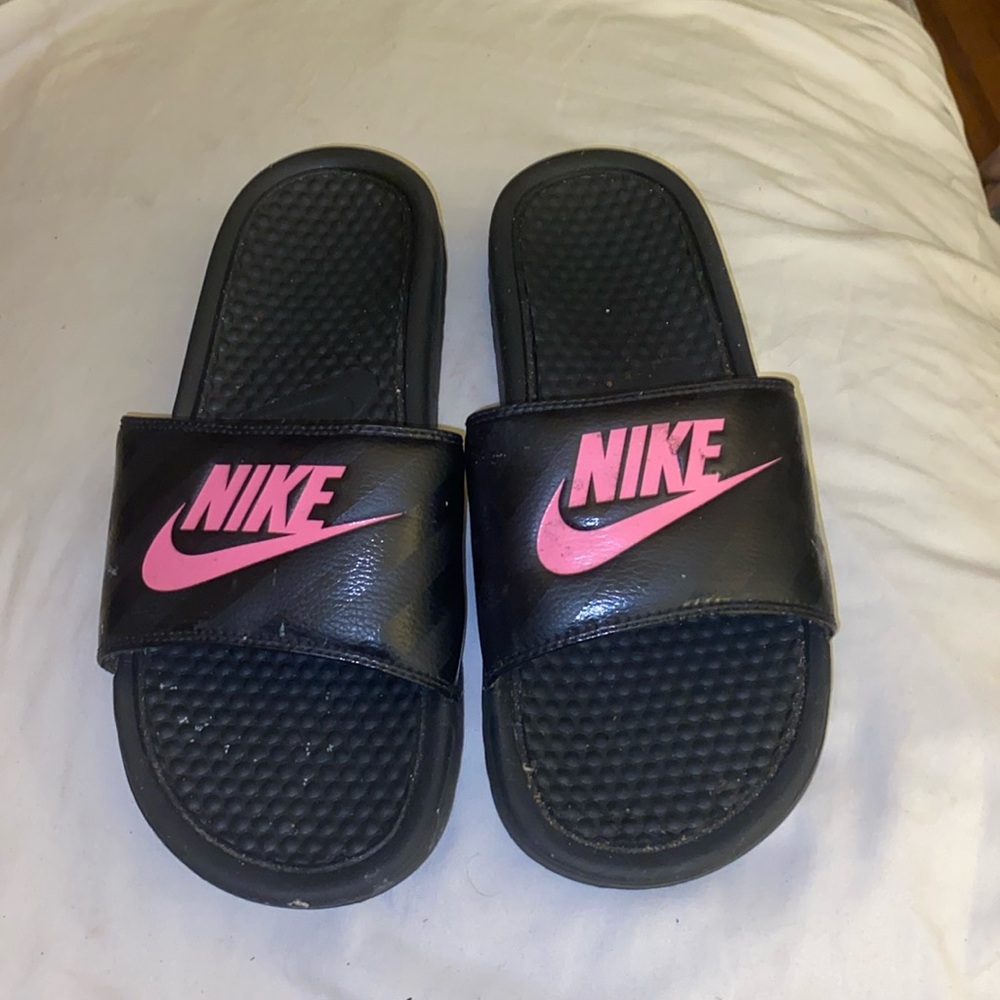 Black and pink Nike slides.